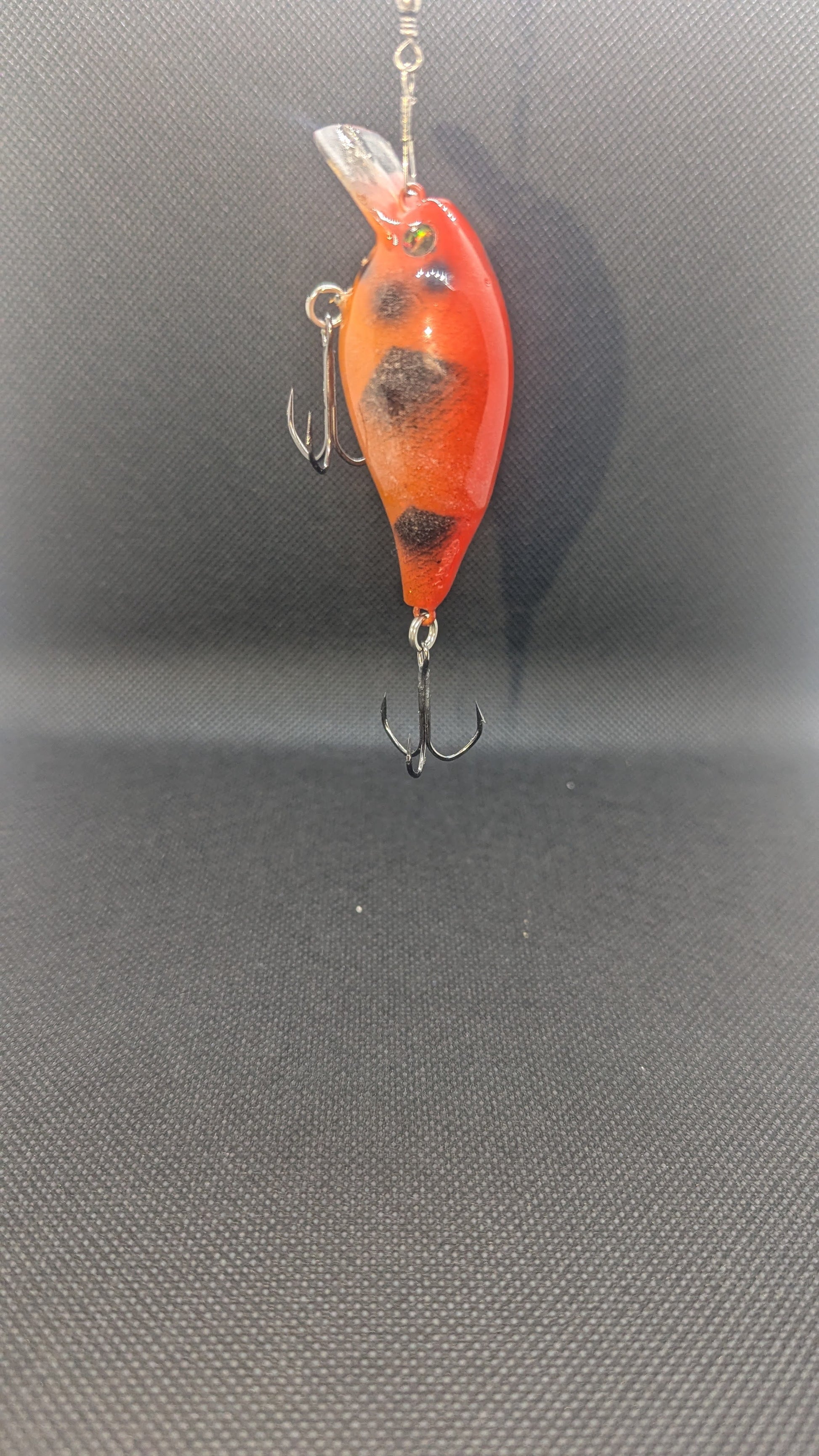 Orange and black fishing lure on a gray background