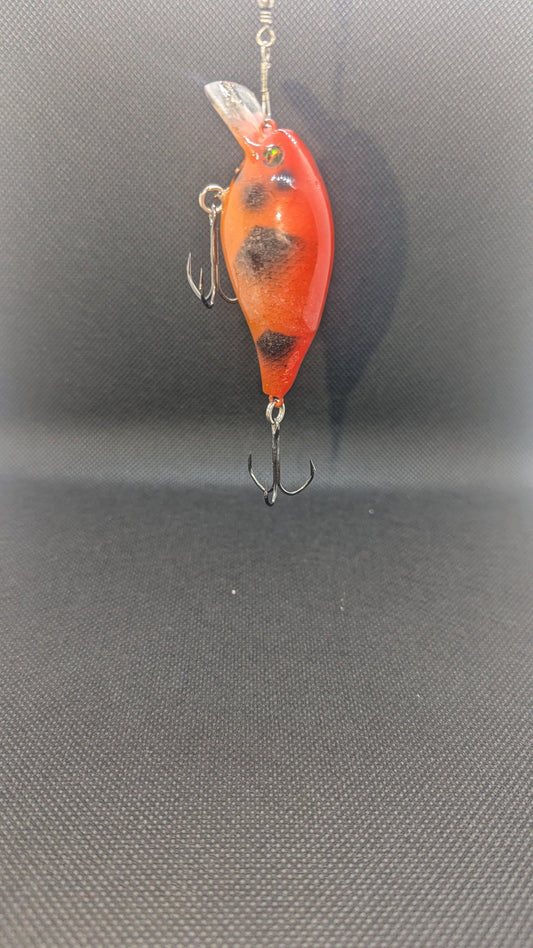 Orange and black fishing lure on a gray background
